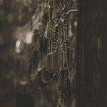 silver-colored god tags hanging on hooks shallow focus photography